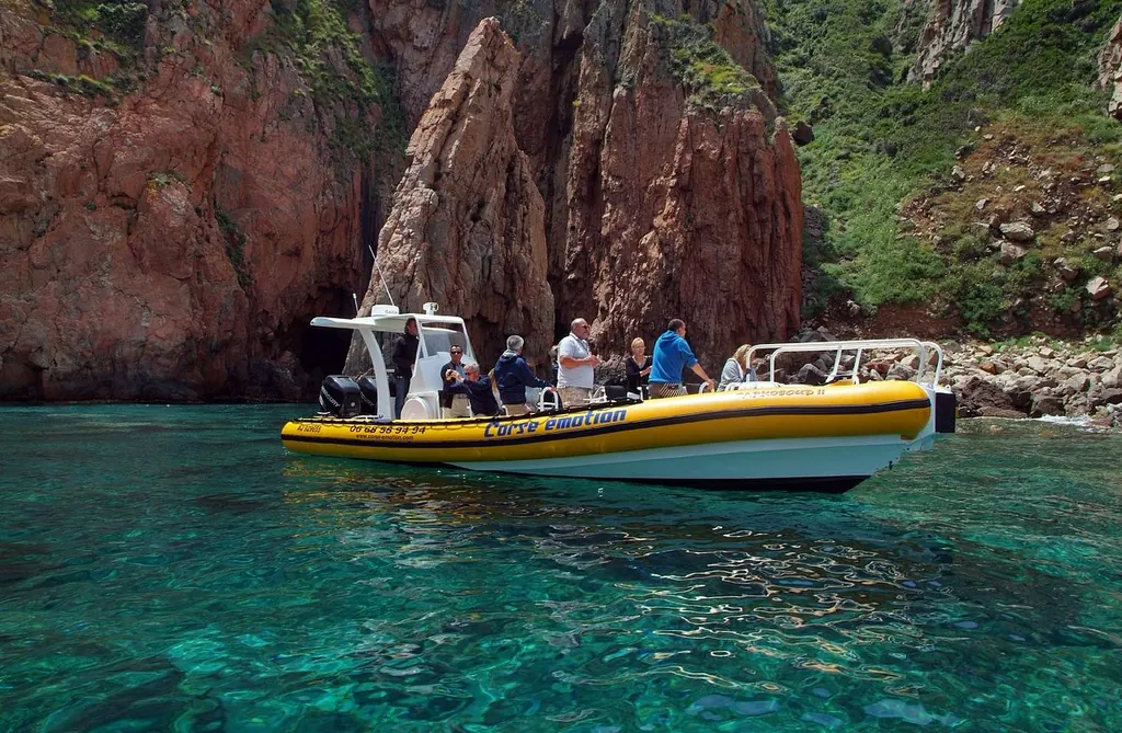 Corse Émotion’s yellow RIB and its passengers below the red cliffs of the Gulf of Porto