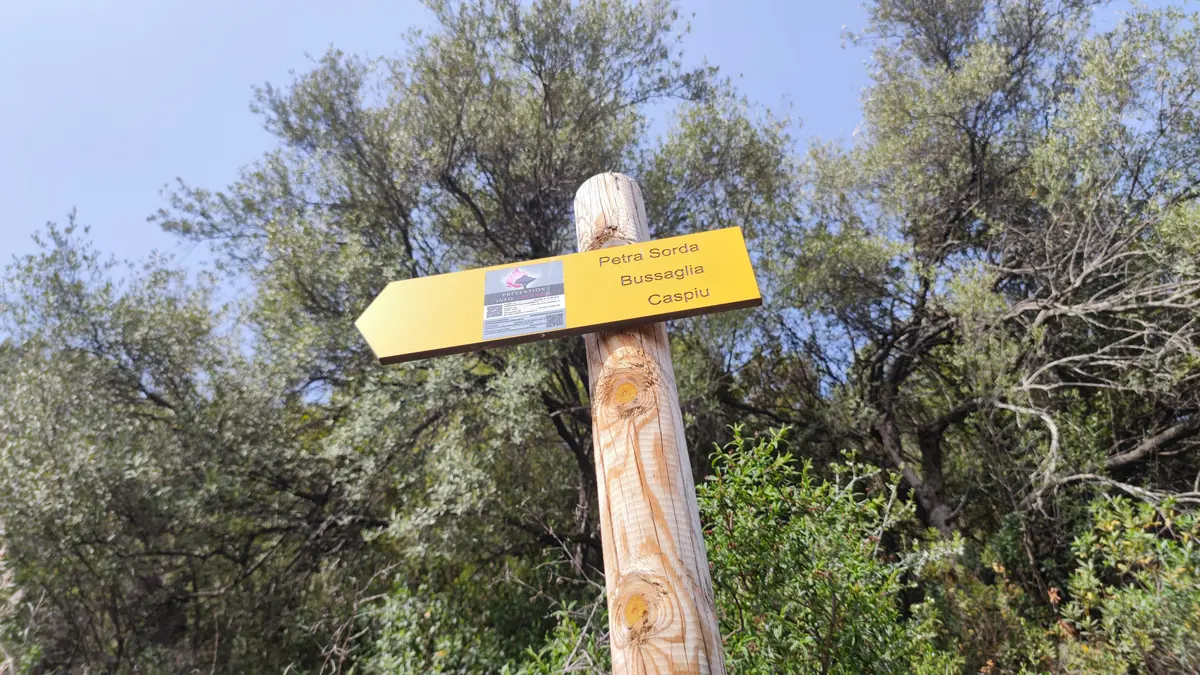 Yellow waymarking sign pointing to Petra Sorda, Bussaglia and Caspiu