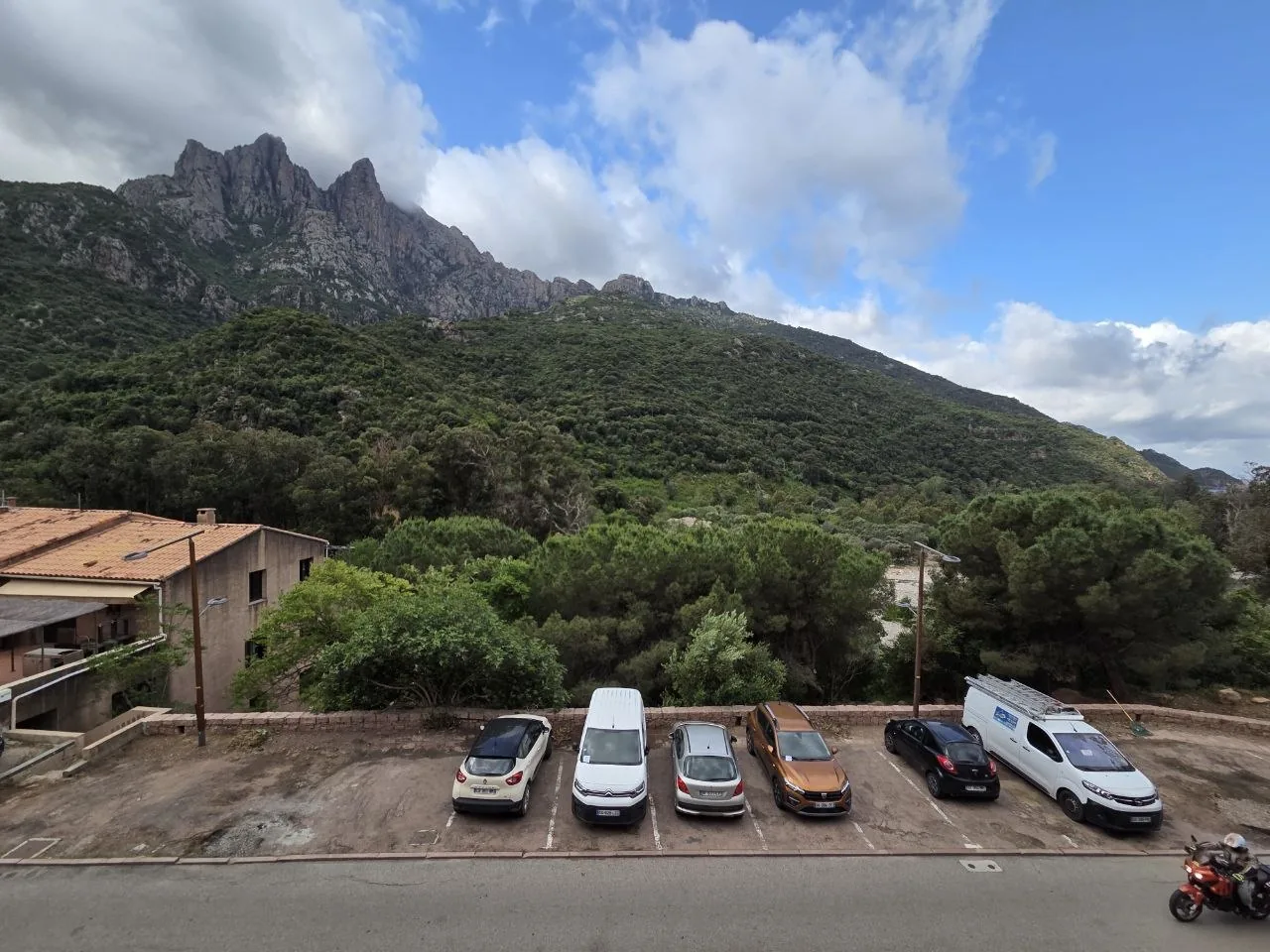 Le parking public devant l'Hôtel Le Vaïta à Porto, avec vue sur le Capo d'Orto, Corse