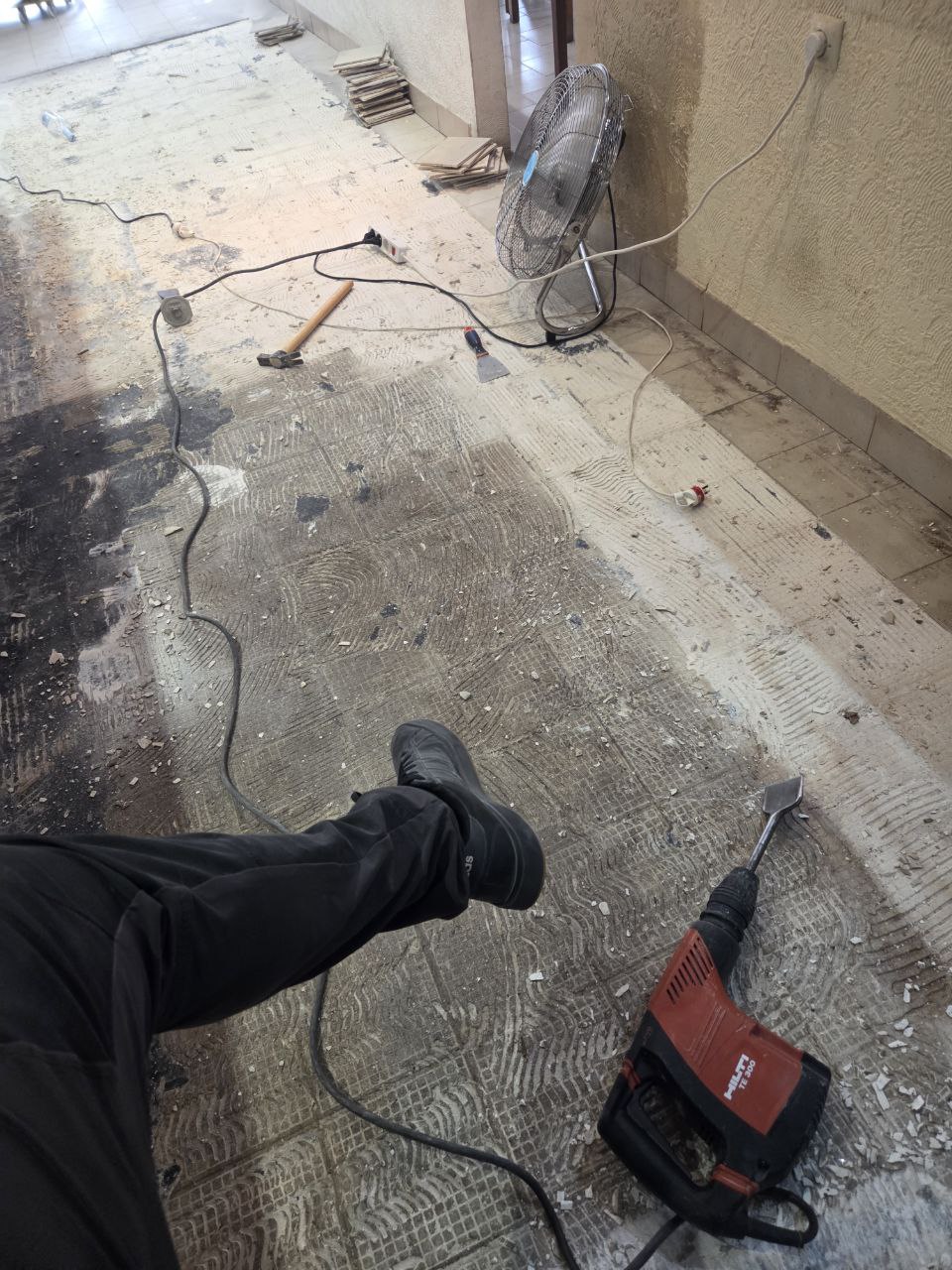 Dépose du carrelage au marteau-piqueur au rez-de-chaussée de l'hôtel après le dégât des eaux