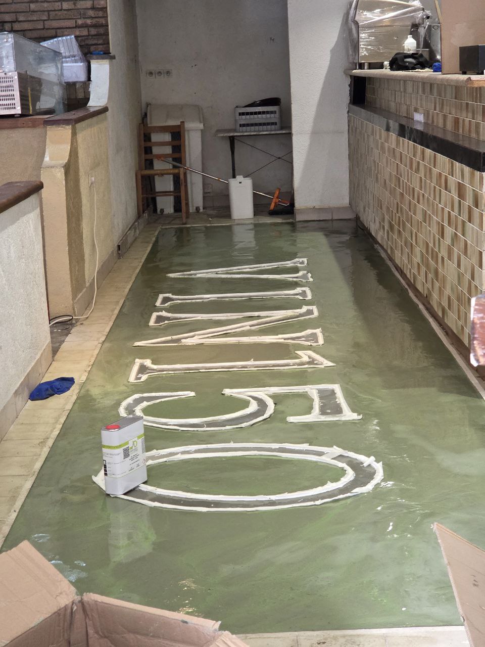 Coulage du ragréage coloré autour des lettres VIN 150 au sol du rez-de-chaussée