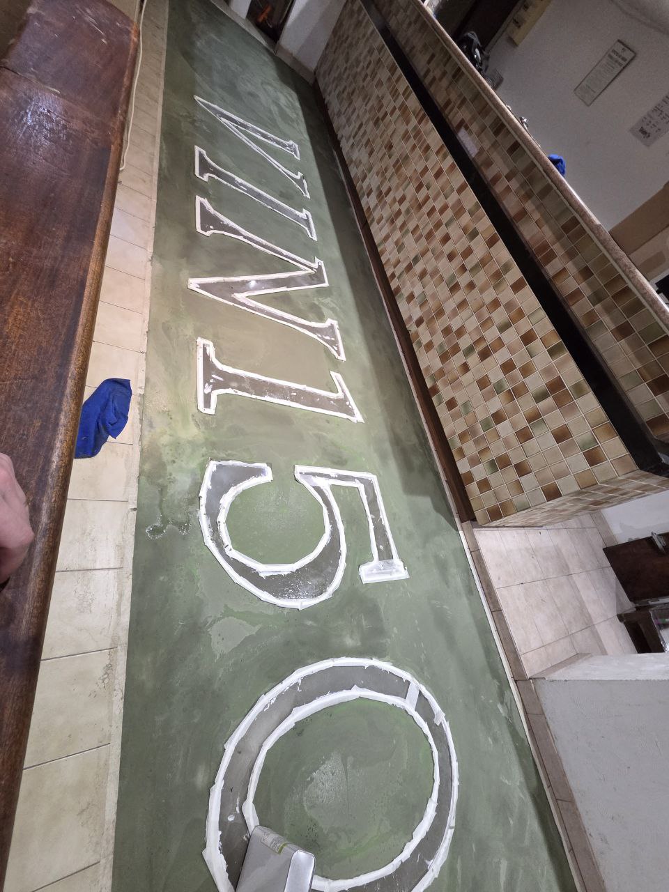 Gros plan sur les lettres géantes imprimées et posées sur le sol avant le coulage du ragréage coloré